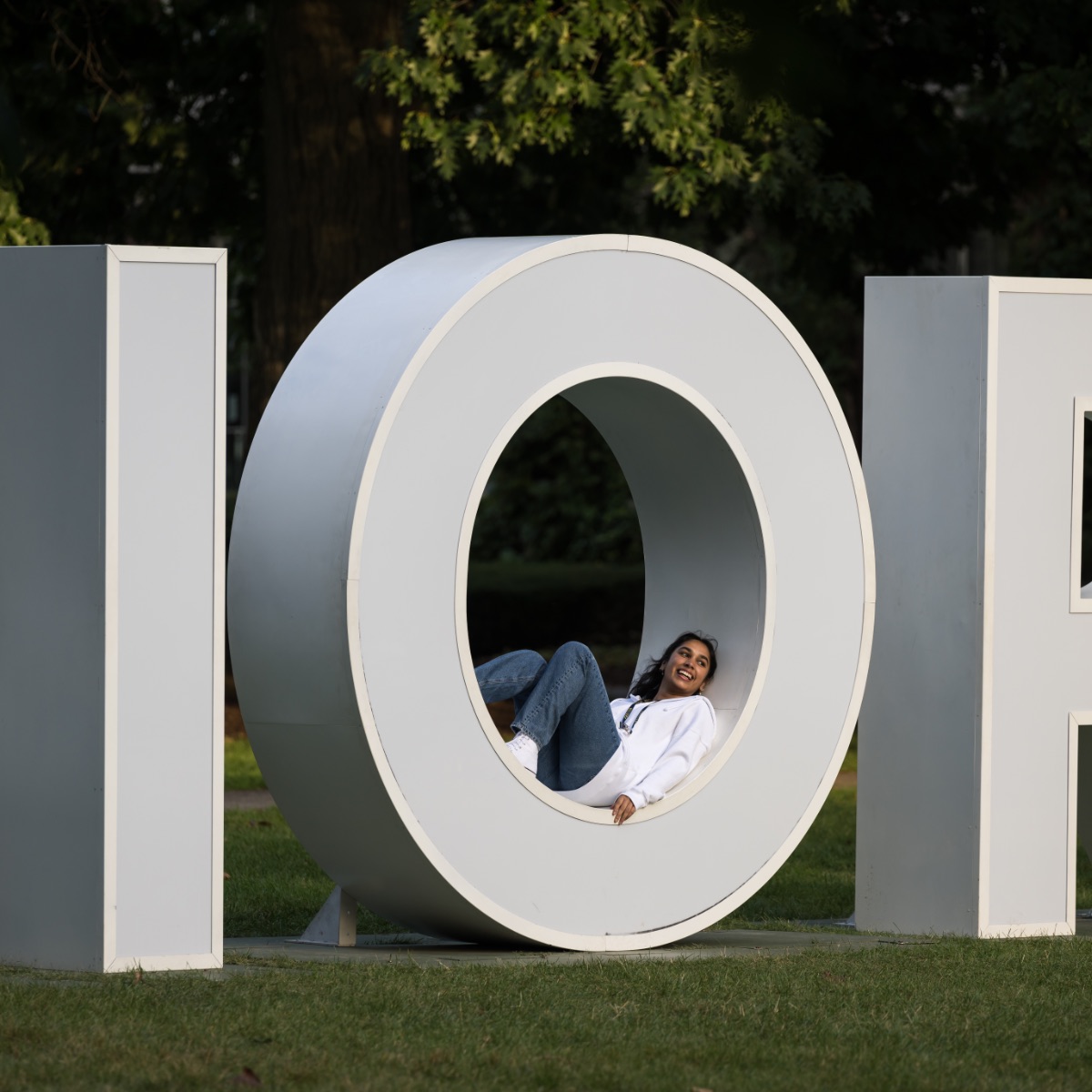 University of Rochester student lays in the O of the large Meliora letters
