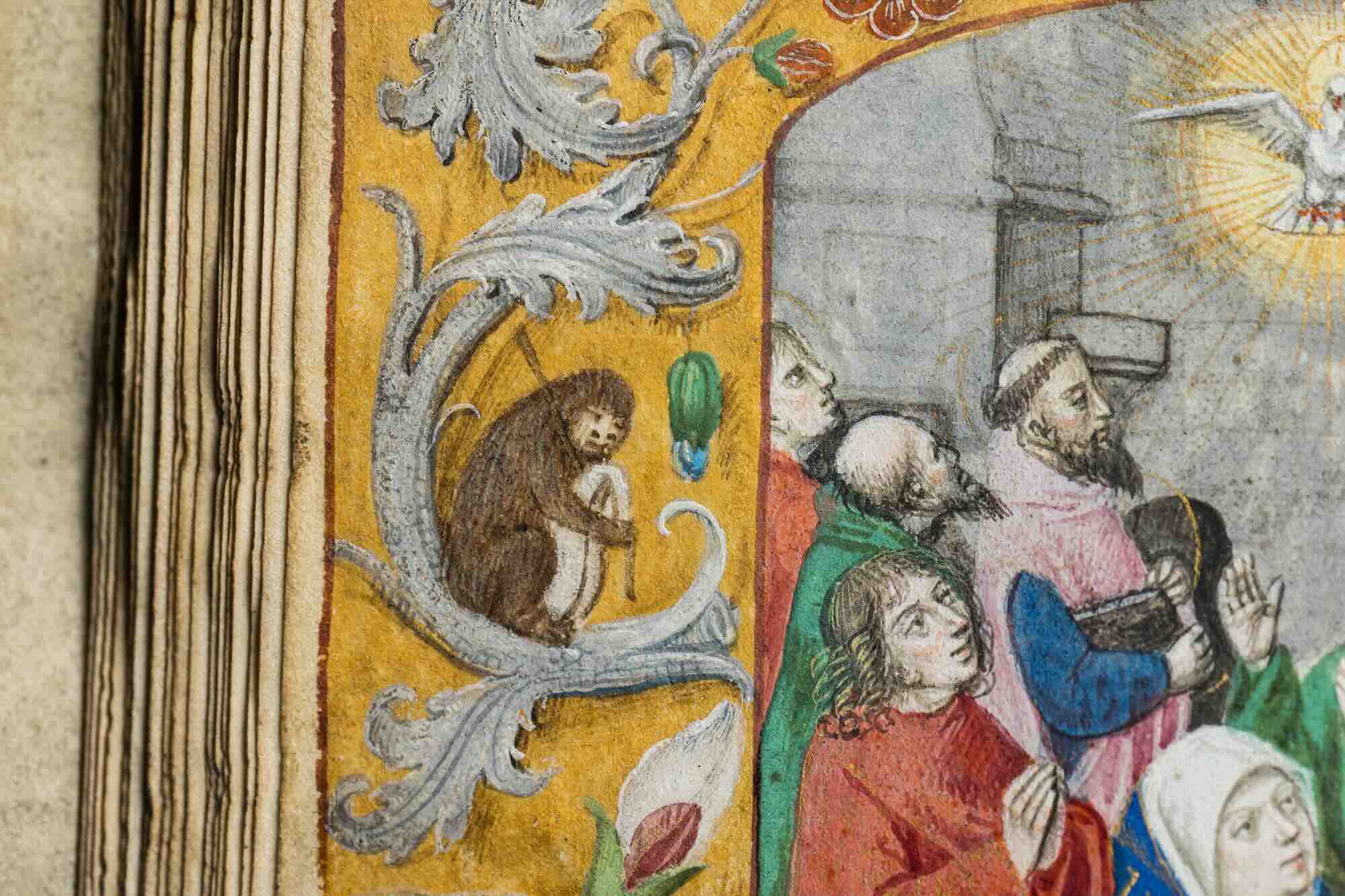 Close-up view of a page from the Ghent-Bruges Book of Hours, showing paintings of saints and a decorative border.